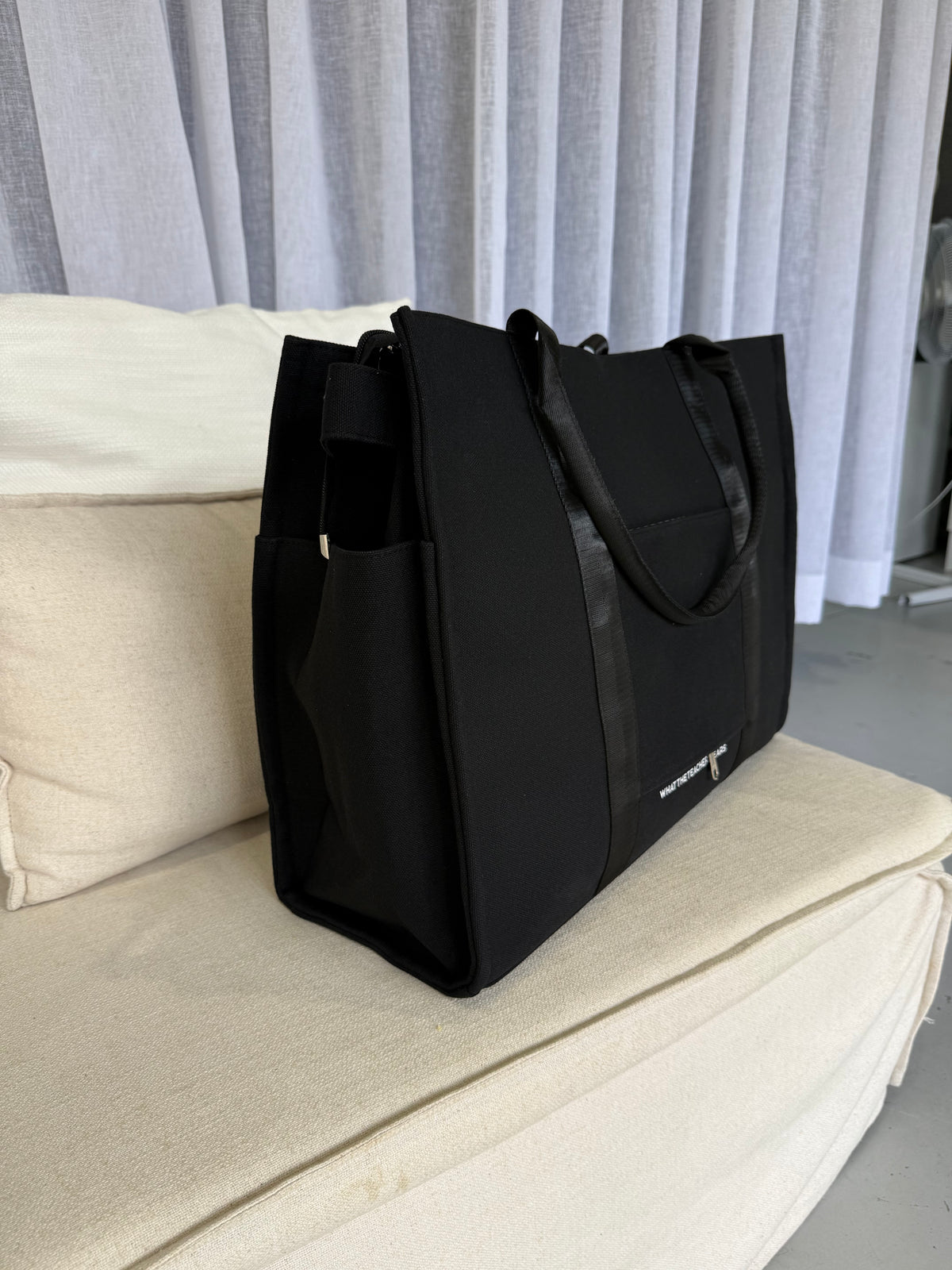 Handle and strap detail on the black Plain Tote